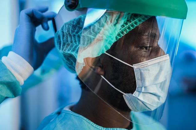 Médicos en el trabajo dentro del hospital durante el brote de coronavirus: enfoque en el ojo del hombre africano