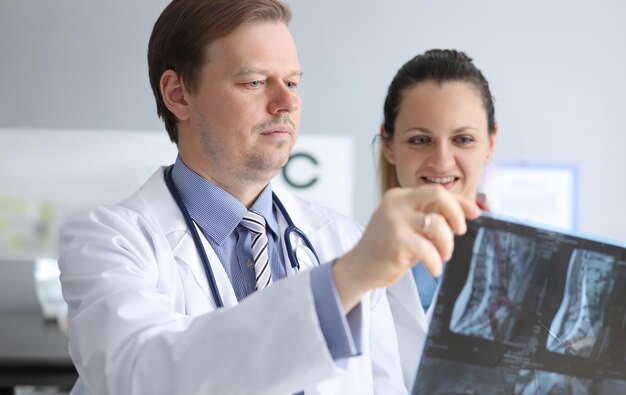 Foto los médicos varones y mujeres miran cuidadosamente una radiografía