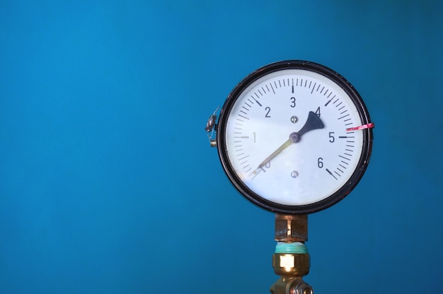 El medidor de presión muestra presión cero en una pared azul. Pared abstracta.