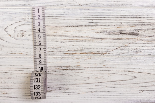 Foto medidor de sastre blanco cinta métrica sobre fondo de madera