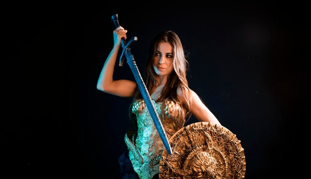 Medieval, guerrera valquiria, mujer con capa de hierro de armadura dorada y gran espada guerrera