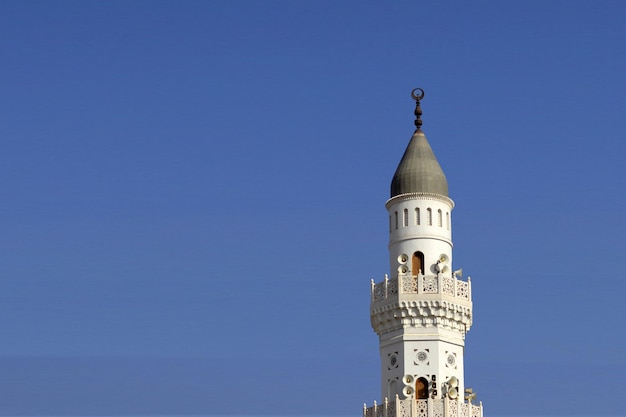 Foto medina, arabia saudita - mezquita quba en medina. torre de la mezquita de quba en fondo azul aislado