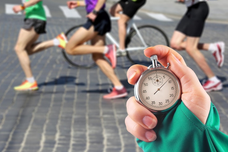 Foto medindo a velocidade de corrida de um atleta usando um ponteiro de cronômetro mecânico com um cronômetro no fundo das pernas de um corredor
