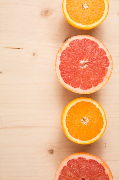 Medio corte de naranja y pomelo plano sobre madera