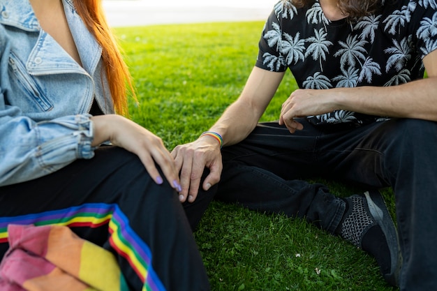 Medio cuerpo de pareja en ropa casual sentada en un parque