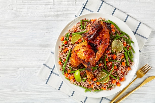 Medio pollo asado con arroz integral en un plato