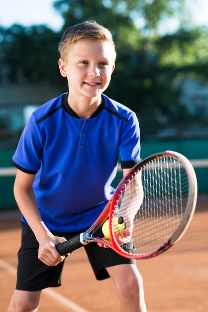 Foto médio, tiro, criança, preparar, para, servir, a, bola