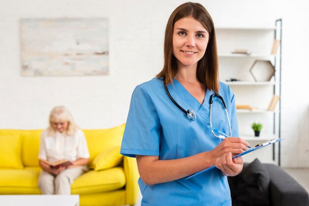 Foto médio, tiro, médico feminino, com, azul, área de transferência, olhando câmera