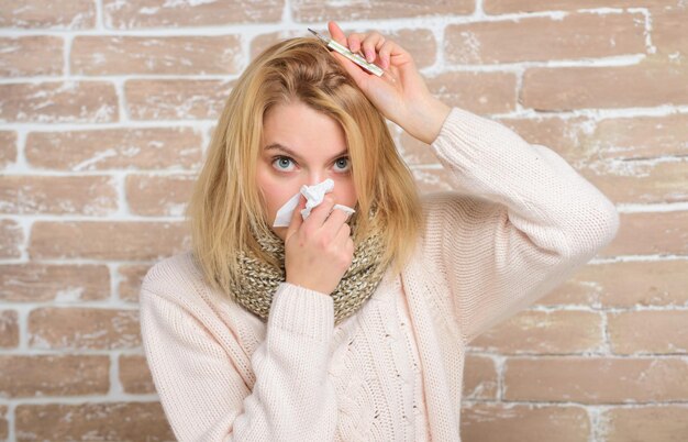 Medir la temperatura Remedios para romper la fiebre Concepto de alta temperatura La mujer se siente muy enferma Cómo bajar la fiebre Síntomas y causas de la fiebre Niña enferma con fiebre Niña con termómetro y tejido