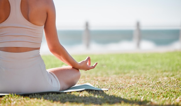 Meditação de ioga e mãos de mulher na grama para um estilo de vida saudável, bem-estar corporal e exercícios aeróbicos Esportes pilates treinando e garota fazendo exercícios para mindfulness espiritual zen e paz no parque
