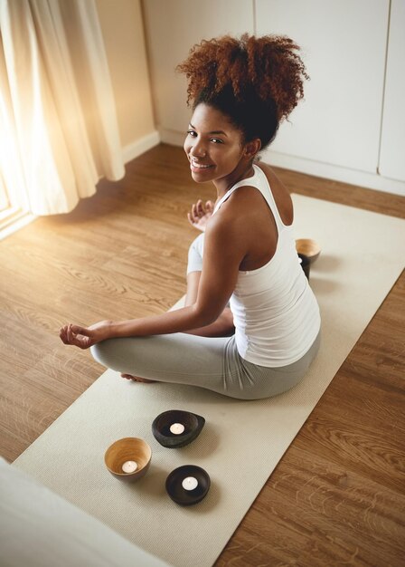 Meditação e retrato de mulher calma em ioga para bem-estar espiritual ou exercício saudável em casa Ioga feminina feliz relaxando ou meditando no tapete com sorriso para bem-estar mental, saúde ou consciência