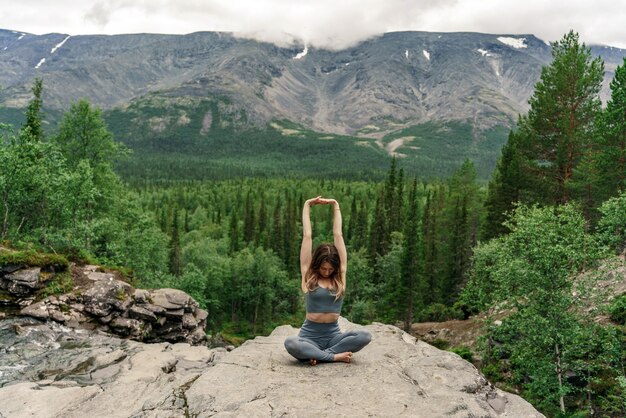 Foto meditación y armonía, una entrenadora hace ejercicio de yoga asana contra el telón de fondo