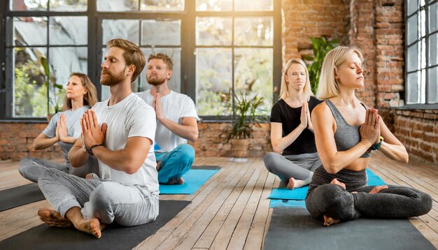 Foto meditación en grupo en el estudio de yoga hombres y mujeres practicando ejercicios de respiración concepto de trabajo de respiración