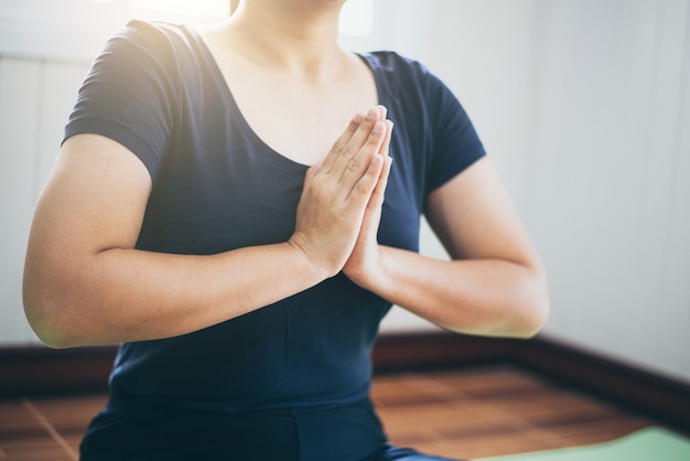 Meditación de mujer joven mientras practica yoga en el interior. Mujer ejercicio vital y meditación para fitness estilo de vida saludable y concepto de Yoga, calma y relajación