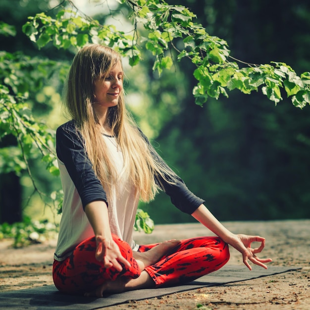 Meditación Mujer joven positiva meditando al aire libre