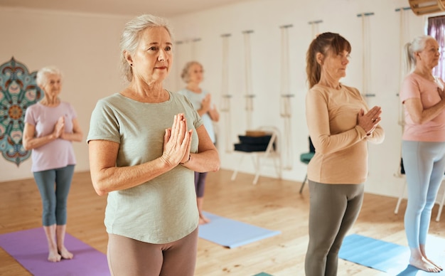 Meditación de yoga y fitness con una mujer mayor en una clase de ejercicio para el bienestar holístico o la salud mental Gimnasio zen y meditación con una yogui madura en un estudio para la paz o el equilibrio interior
