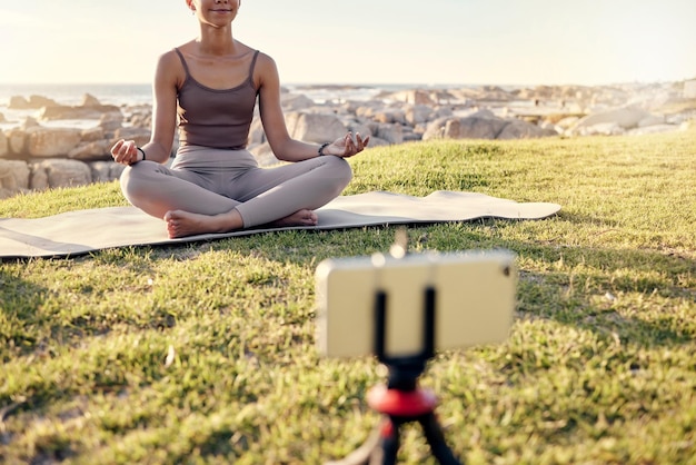 Meditación de yoga y transmisión en vivo de mujeres en la naturaleza en un teléfono inteligente para la curación de la paz y la creación de contenido de atención plena en las redes sociales Influencer o creador de contenido de fitness meditar al aire libre en video