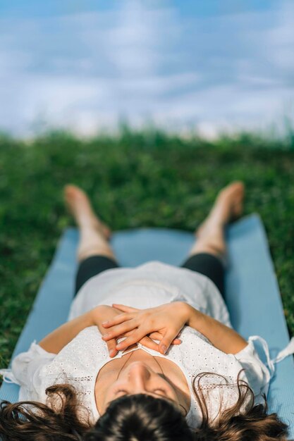 Foto meditando junto al agua joven acostada junto al agua y meditando