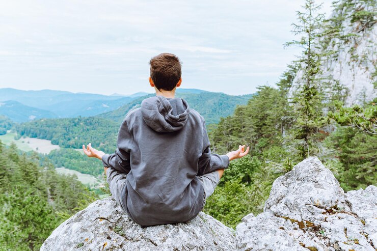 Foto meditation allein auf der bergspitze der klippe, blick von hinten