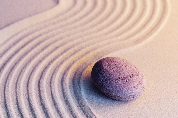 Meditations-Zen-Garten mit Steinen auf Sand, getöntes Bild