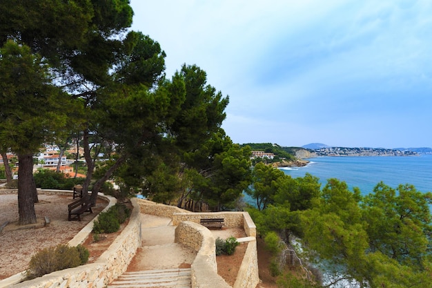 Mediterrane Pinien in einem Stadtpark in Moraira mit Blick auf den Strand Playa El Portet im Mittelmeer Alicante Spanien