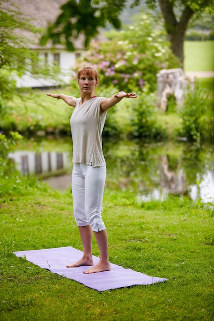 Meditieren in der Natur Aufnahme einer Frau beim Yoga im Park