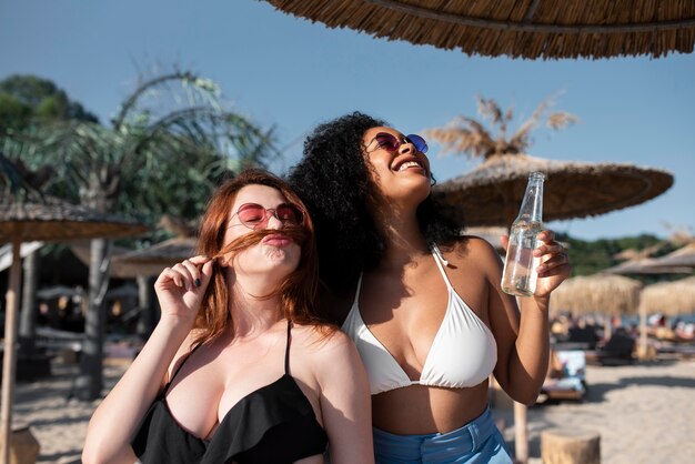 Medium Shot Freunde am Strand mit Drink