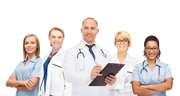 Medizin, beruf, teamarbeit und gesundheitskonzept - internationale gruppe lächelnder mediziner oder ärzte mit klemmbrett und stethoskopen auf weißem hintergrund