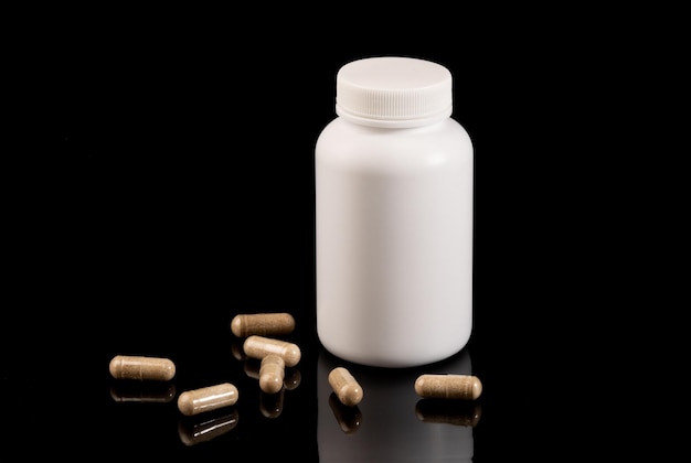 Medizin- und Gesundheitskonzept Pillen und ein Glas liegen auf schwarzem Hintergrund