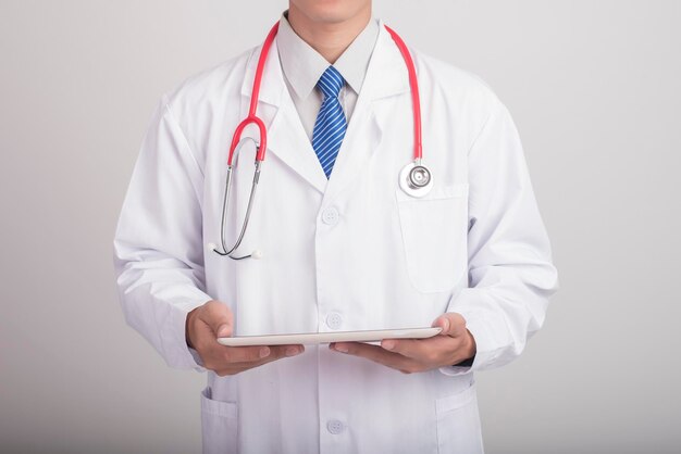 Mediziner, der ein Stethoskop in der Hand hält und mit modernen medizinischen Ikonen arbeitet