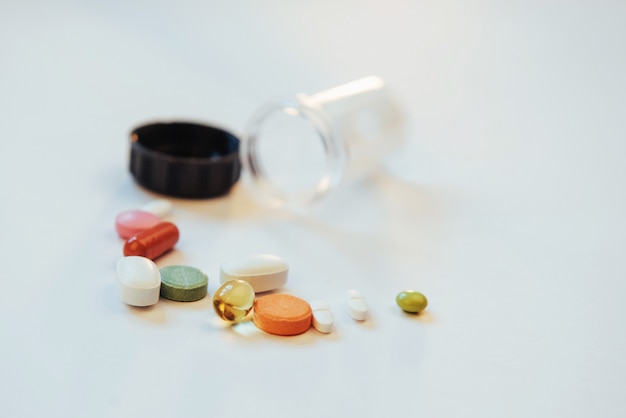 Medizinische bunte Pillen, Kapseln oder Ergänzungen für die Behandlung und das Gesundheitswesen auf einem hellen Hintergrund