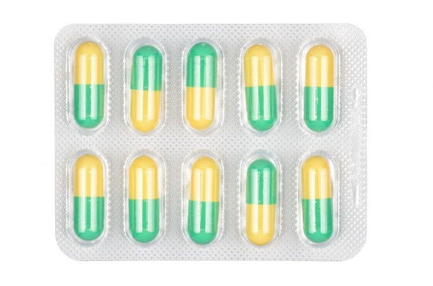 Medizinische grüne und gelbe Pillen in der Blase lokalisiert auf weißem Hintergrund