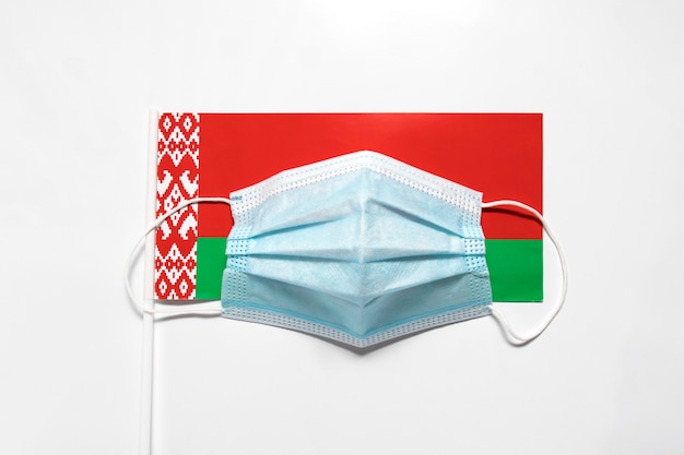 Medizinische Maske auf der Flagge der Republik Belarus.