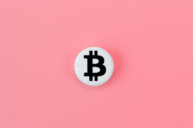 Medizinische Pille mit einem Bitcoin-Zeichen auf rosa Hintergrund Bitcoin-Technologiekonzept in der Medizin