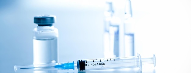 Medizinische Spritze mit einer Nadel und einer Bollte mit Impfstoff