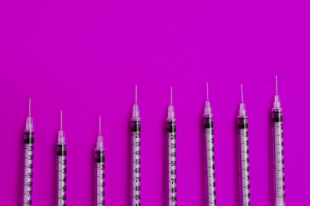 Medizinische Spritzen auf rosa Hintergrund