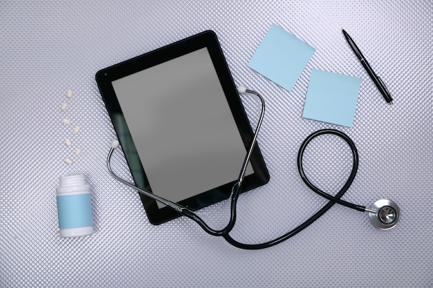 Medizinische Tablette mit Stethoskop auf weißem Hintergrund