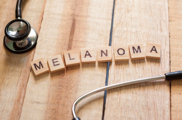 Foto medizinische und gesundheitspflege wörter schreiben typografie buchstabenkonzept krebs melanom