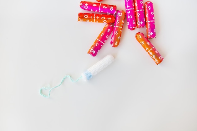 Medizinischer weiblicher Tampon in rosa und orangefarbener Verpackung auf weißem Hintergrund Hygienischer weißer Tampon für Frauen Wattestäbchen Menstruationsverhütung