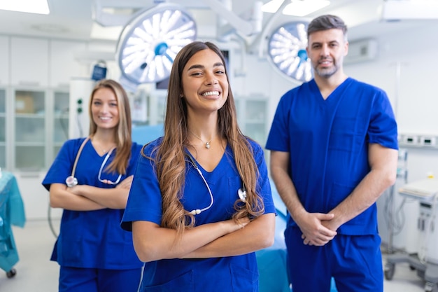 Foto medizinisches fachpersonal steht zusammen konzept des gesundheitsschutzes erfolgreiches team von ärzten schaut in die kamera und lächelt, während es im krankenhaus steht