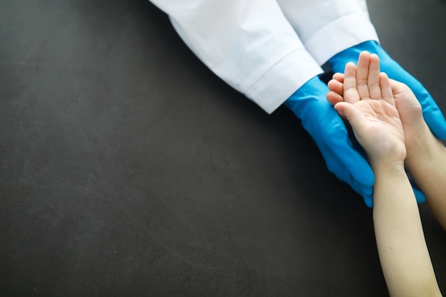 Foto medizinisches konzept. der arzt in handschuhen hält die hand des patienten. die moralische hilfe des arztes für seine patienten. beratung beim kardiologen. epidemie.