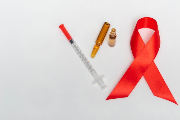 Medizinisches Konzept Dezember Welt-Aids-Tag. Bürokratie, Ampullen Medizin und Spritze auf weißem Hintergrund. Safer-Sex-Konzept. Nahaufnahme