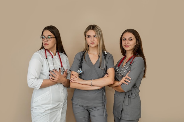 Medizinisches Team mit drei weiblichen Ärzten, die zusammen im isolierten Hintergrund stehen