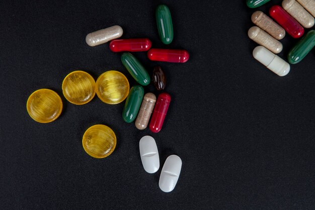 Medizinpillen in Tabletten und Kapseln auf schwarzem Hintergrund