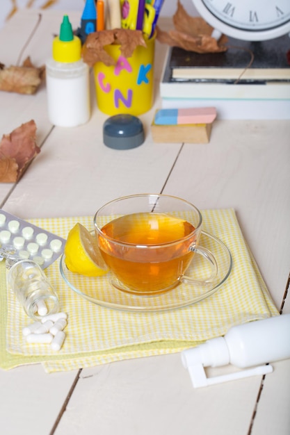 Foto medizintasse kräutertee und zitrone vor dem schulbedarf