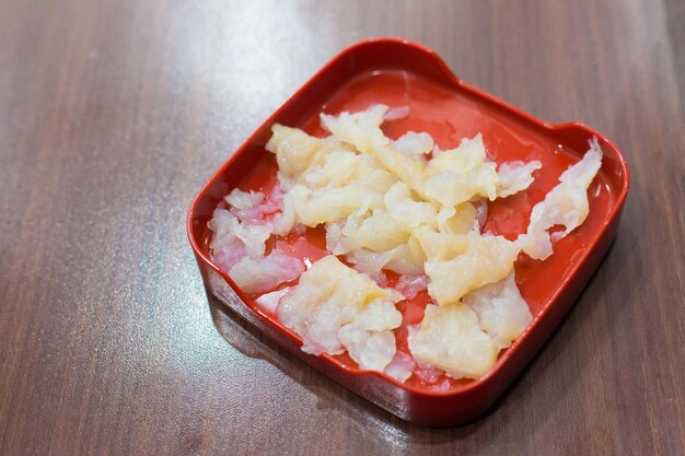 La medusa fresca es un pedido de mariscos que se sirve en un buffet shabu sukiyaki en un restaurante de madera.