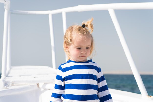 Meer ist seine Berufung Baby Junge genießen Sie Urlaub Kreuzfahrtschiff Kind süßer Seemann Jacht sonniger Tag Junge entzückender Seemann gestreiftes Hemd weiße Yacht Reise um die Welt Abenteuer des jungen Seemanns, der Meer reist