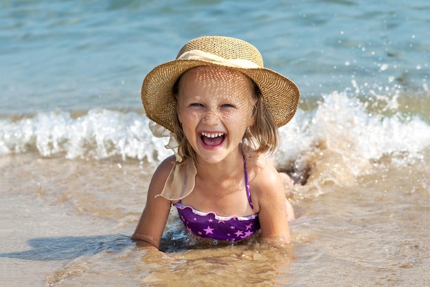 Meer Kinder Ferienkonzept Glückliches Kind liegt am Meer im Wasser Kleines Mädchen hat Spaß am Sandstrand