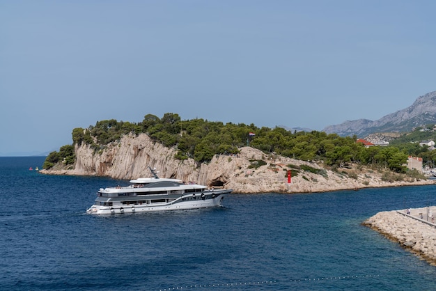 Meer Sommerlandschaft Ein großes Touristenschiff betritt die Bucht in Makarska Kroatien Felsenküste Panorama Berge Meer Sonne