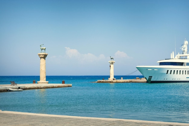 Meerblick auf Hirschstatuen und Schiff am Eingang zum Mandraki-Hafen, wo der Koloss von Rhodos Griechenland stand